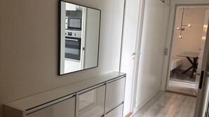 A modern kitchen with a built-in oven, a large mirror, and a sliding door leading to a bathroom. - Cozy Viby Apartment Near Kjaerlsund (Aarhus)