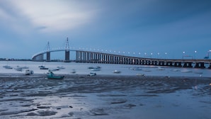 Eine Anlegestelle mit Booten und einer Brücke im Hintergrund.