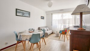 Un comedor con una mesa dispuesta para dos, un sofá y una lámpara.