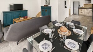 A modern dining area with a glass table set for six, surrounded by chairs.
