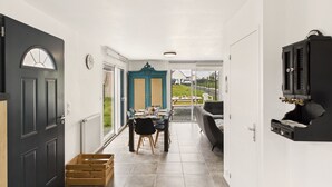 A hallway leading to a dining area with a view of the outdoors.