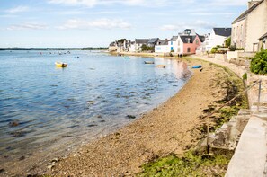 A coastal scene with boats on calm water, a pebble beach, and buildings along the shore. - Lovely house for 4 300m from the beach and pond (Ile Tudy)