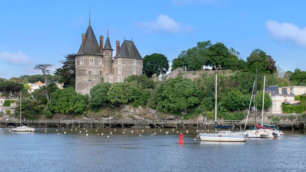 A historic castle with a moat, surrounded by lush greenery and a calm river. - On the Quai de Pornic, Apartment for 4 (Pornic)