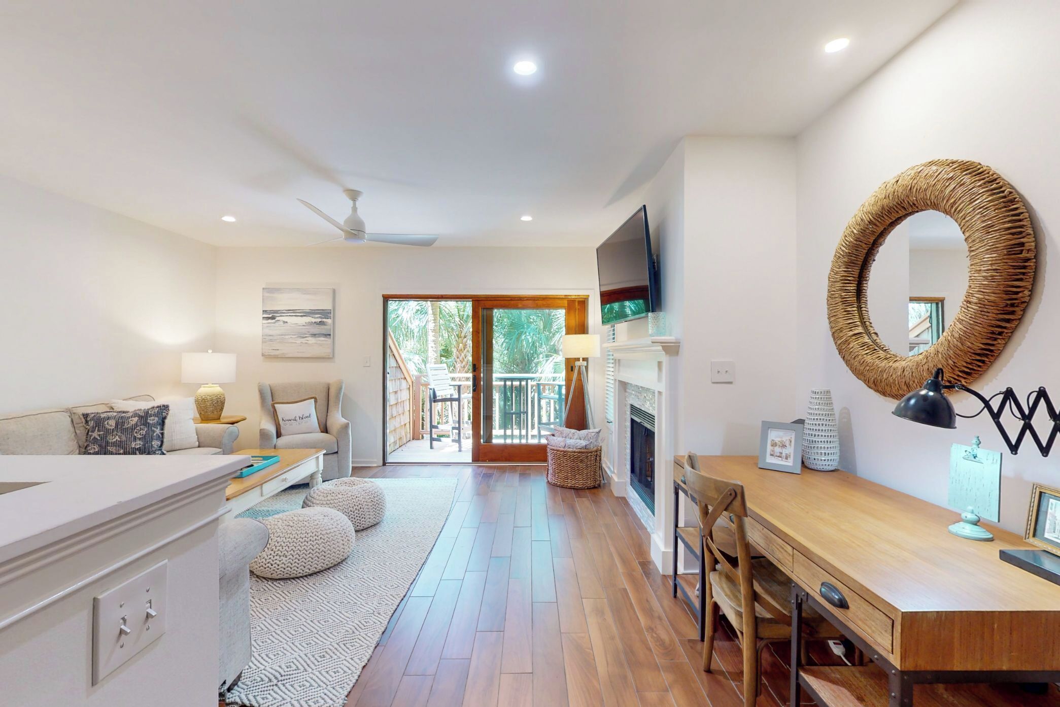 A modern kitchen with a wooden dining table, a built-in oven, and a large mirror.