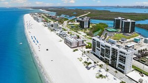 Ein Hotel an der Küste mit Blick auf den Strand, mehreren Gebäuden und blauem Himmel.