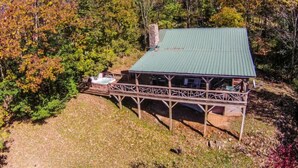 A cabin with a green roof, a deck, and a hot tub. - Silverleaf (Zionville)