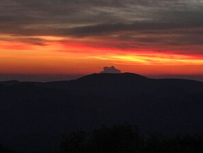 Silhouetten van een bergketen tegen een zonsondergang.