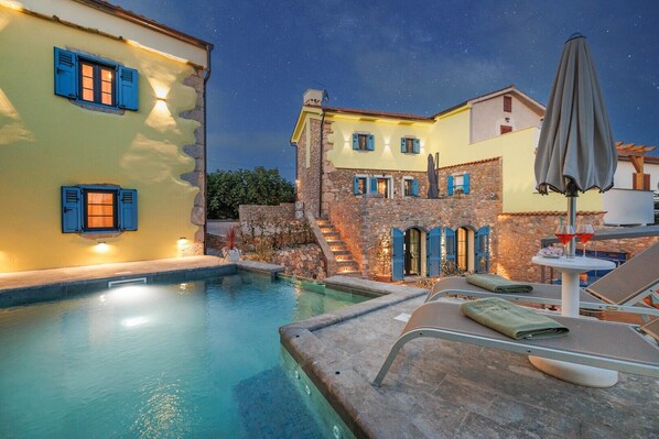A pool area with a stone wall, a staircase, and a lounge chair. - Villa Melary with the Pool, Jacuzzi & Ps5 surrounded with nature. (Kras)