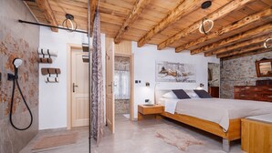 A bedroom with a wooden ceiling, a bed with a headboard, a nightstand, a wooden dresser, and a shower area with a towel rack. - Villa Melary with the Pool, Jacuzzi & Ps5 surrounded with nature. (Kras)