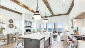 A spacious kitchen with a large island, modern appliances, and a view to the outside.