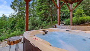 A hot tub under a wooden pergola surrounded by lush greenery. - Pretty Spectacular (Banner Elk)