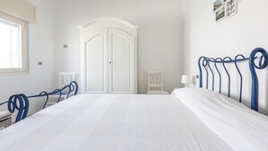 A bedroom with a large bed, white walls, a wardrobe, and a window. - 4002 Villetta Playa del Sol by Barbarhouse (Manduria)