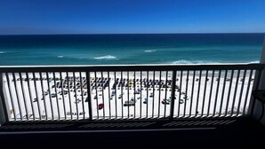 A balcony with a view of a beach and the ocean. - Pelican Beach 1508 1 Bedroom Home (Destin)