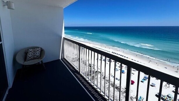 A balcony with a view of a beach and ocean. - Pelican Beach 1508 1 Bedroom Home (Destin)