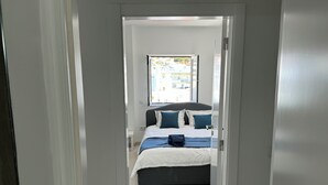 A bedroom with a bed, pillows, and a backpack on the bed. - Casa Isa, Idéalement Située Dans la Vielle Ville, Offre une Incroyable vue mer (Albufeira)
