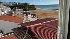 A coastal town with terracotta-roofed buildings, a beach, and a clear blue sky. - Casa Isa, Idéalement Située Dans la Vielle Ville, Offre une Incroyable vue mer (Albufeira)