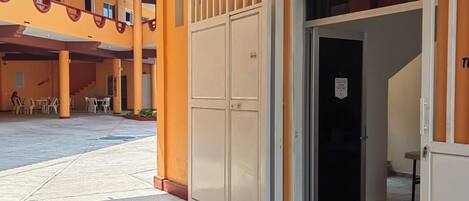 Zona de recepción con puerta cerrada, escalera y asientos al aire libre.