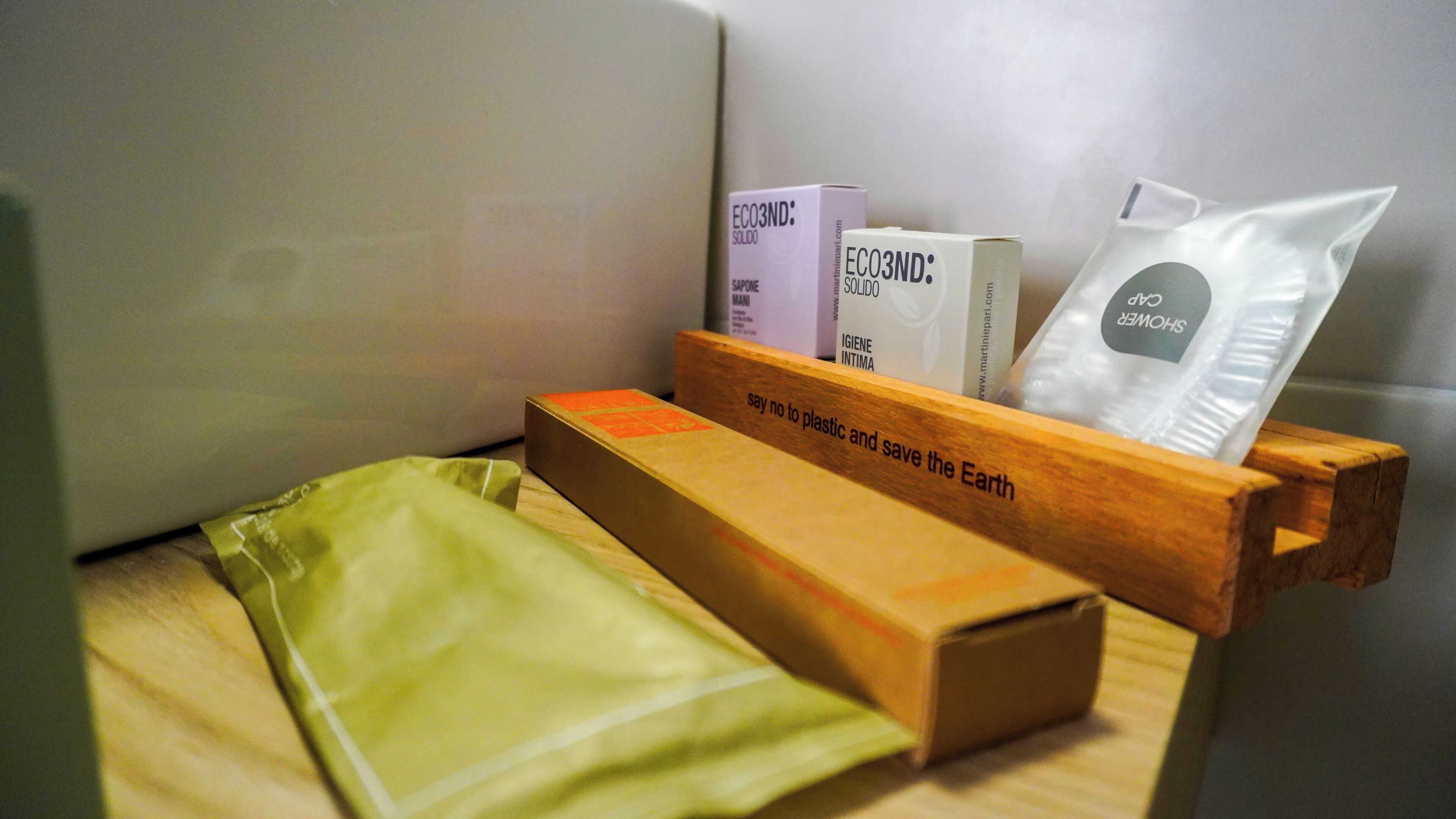 A wooden storage box with eco-friendly products, including a green bag and boxes labeled with "ECO3ND."