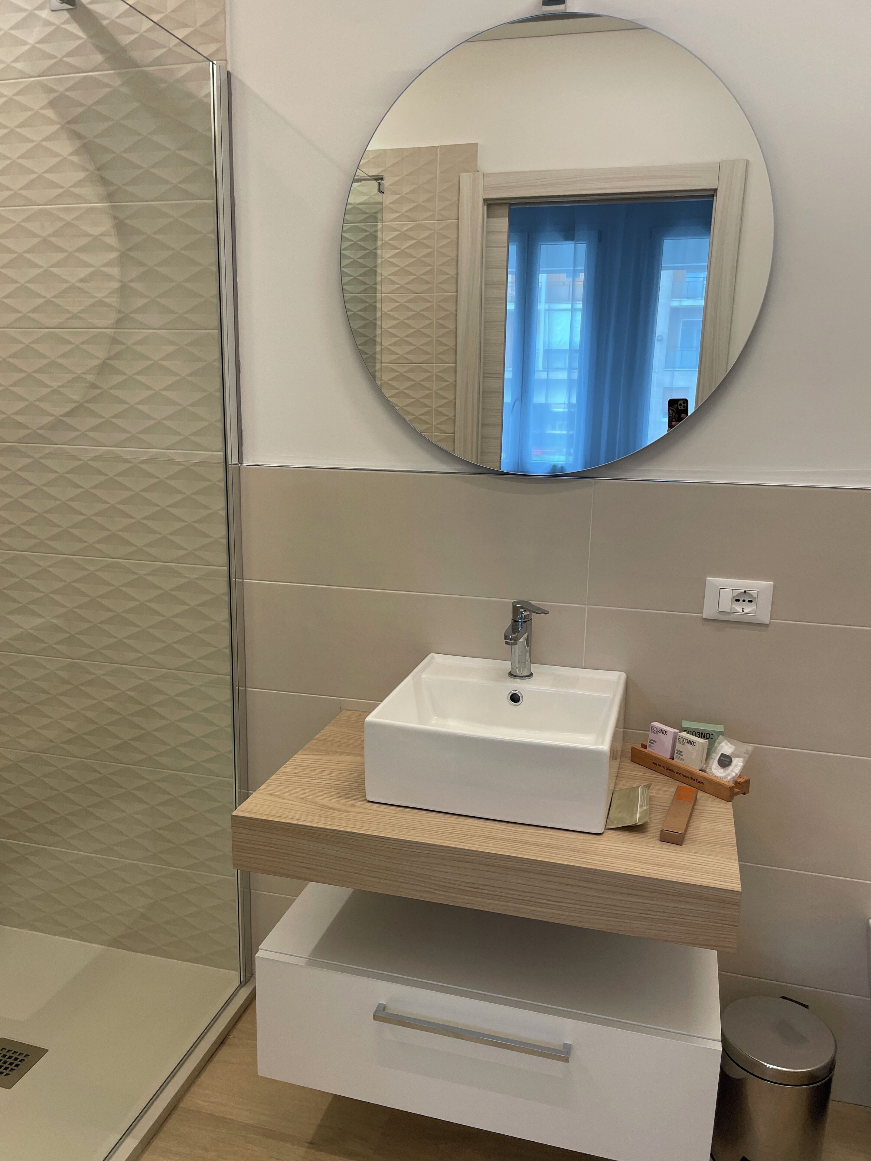Ein Badezimmer mit Waschbecken, Spiegel und Holzkosmetikschrank.
