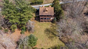 An aerial view of a cabin with a deck, surrounded by dense forest. - Nuttin' Better (Blowing Rock)