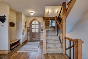 Eine Holztreppe mit Geländer und einer Sitzbank am Fuß.