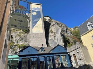 A hotel with a sign reading "Hotel Au Castel de Mirambel" and a nearby "MUSEE PYRENEEN" building. - Castel de Mirambel (Lourdes)