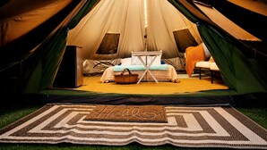 Une tente contenant un lit, une table et une chaise.