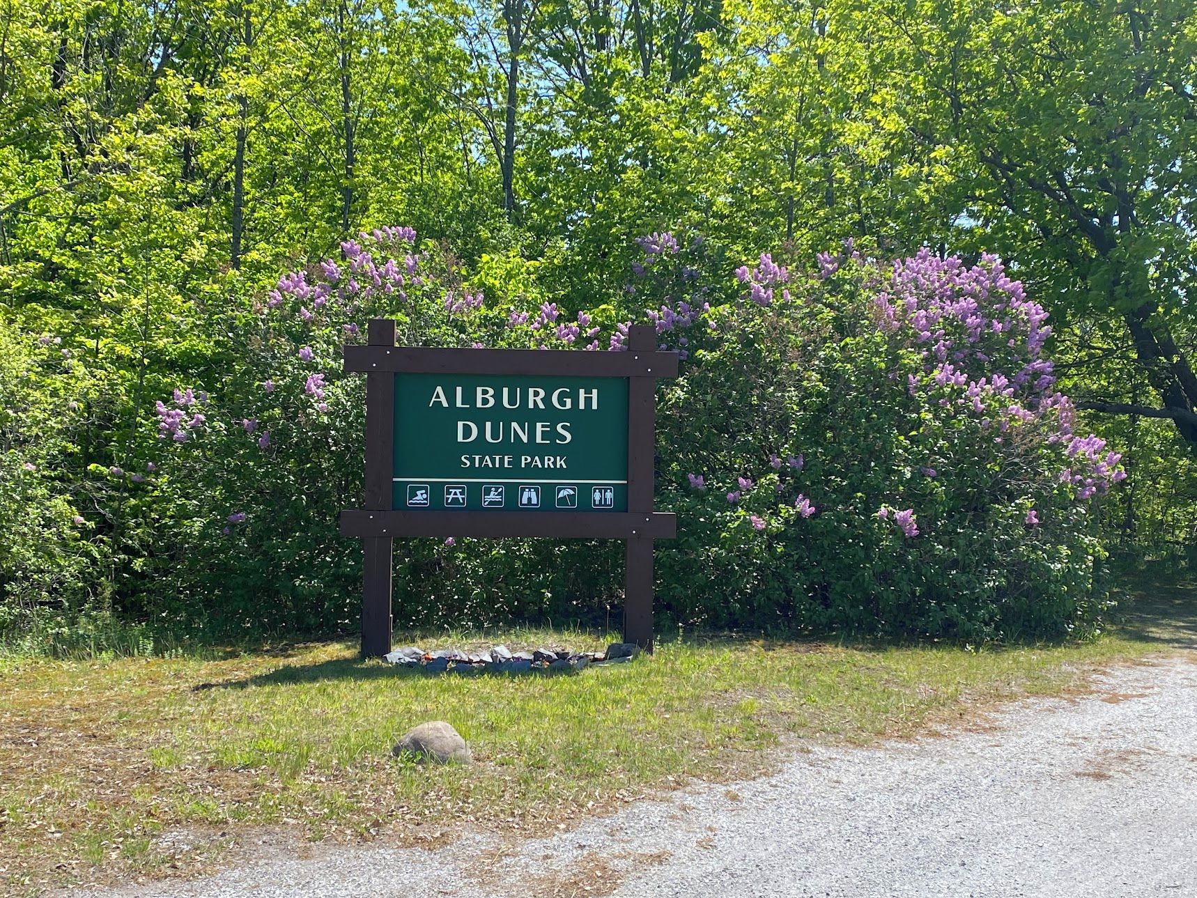 Een bord voor Alburgh Dunes State Park met symbolen die voorzieningen aangeven.
