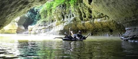 Eine Höhle mit einem Wasserkörper und Personen in einem Floß.