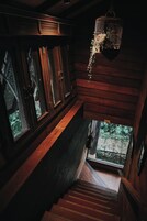Una escalera de madera con una jaula de pájaros colgando del techo.