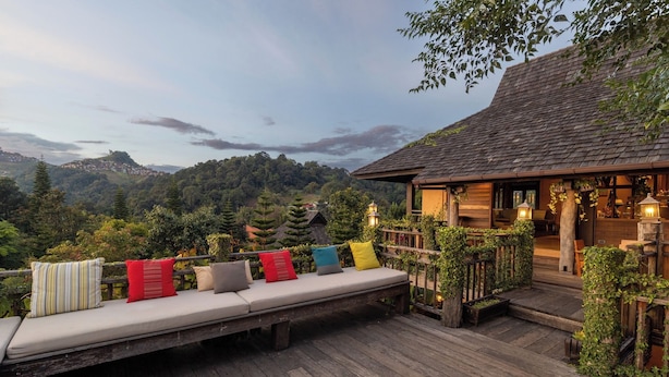 A wooden deck with a bench and cushions, overlooking a mountainous landscape. - Baan Mon Muan  (Mae Rim)