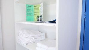 A white shelf with folded white towels and a brochure on the top shelf. - Oparadi "Le Nid" Avec sa Terrasse (Wimereux)