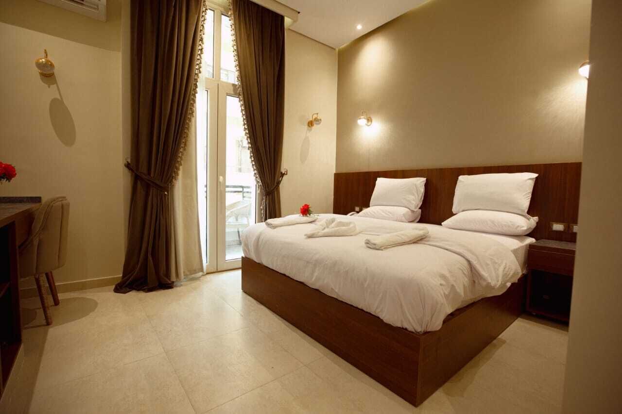 Une chambre d’hôtel avec un grand lit, un bureau et une chaise.