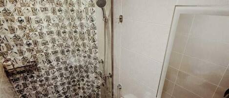 A modern bathroom with a shower, toilet, and sink.