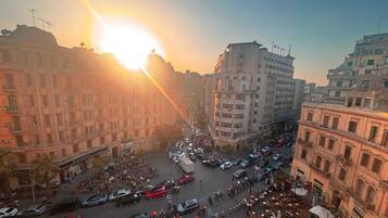 A busy urban street scene with buildings, vehicles, and pedestrians.