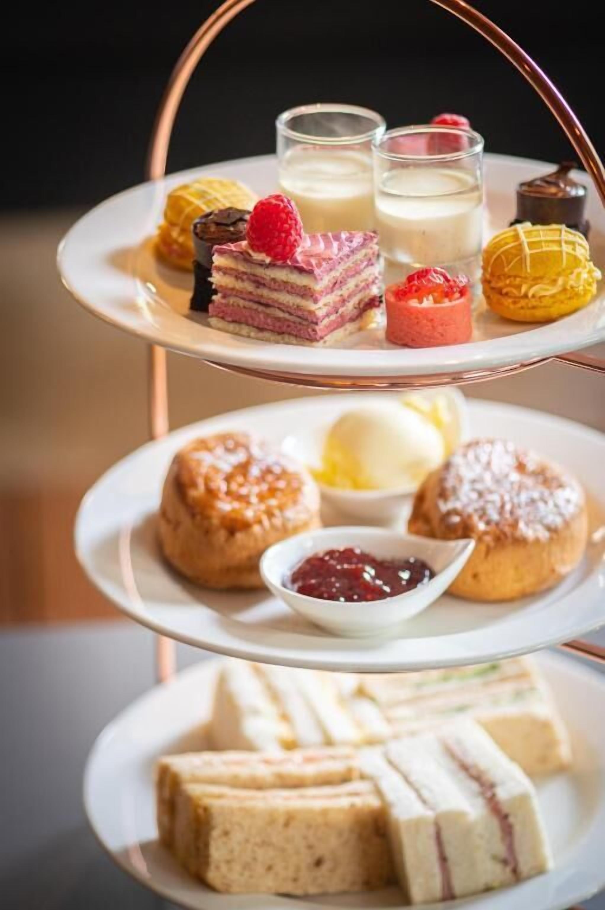 A three-tiered dessert stand with various pastries and desserts.