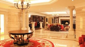 A spacious lobby with a round table, red carpet, and classical decor.