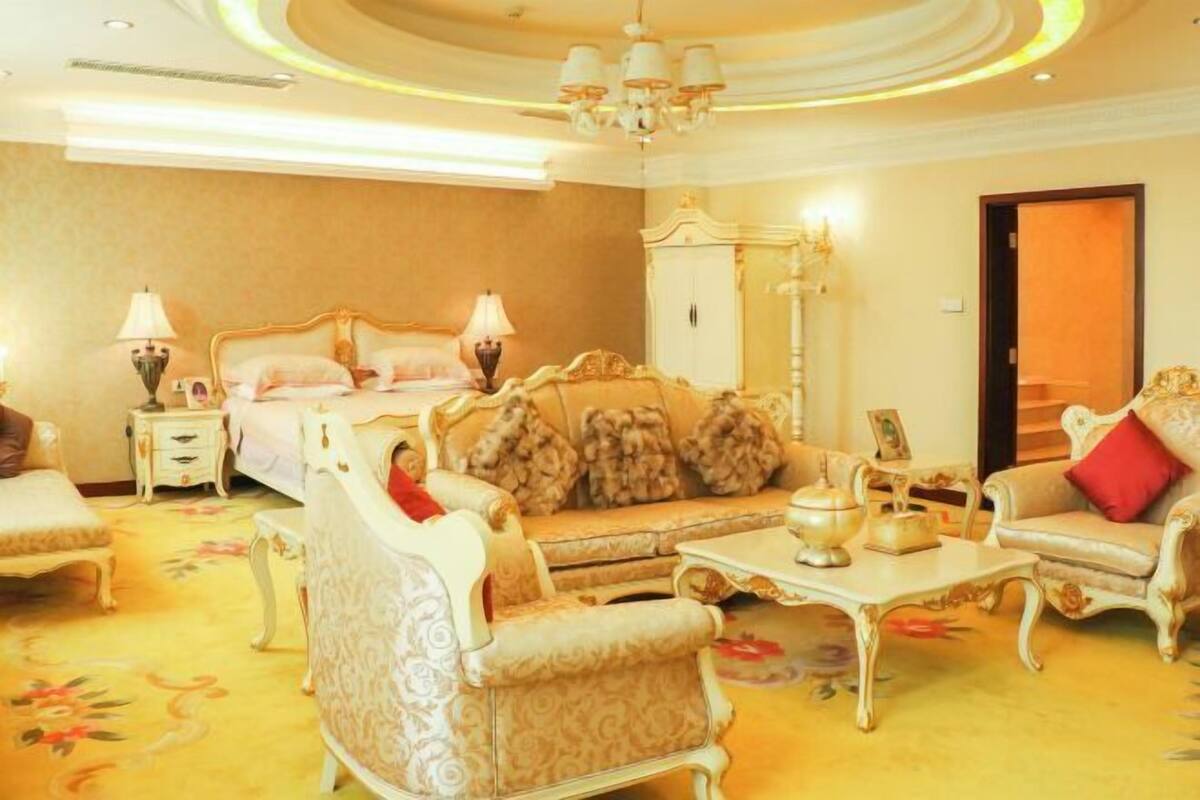 Ein geräumiges Zimmer mit einem großen Bett, einem Sofa, einem Sessel, einem kleinen Tisch und einem Schrank.