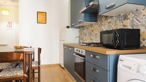 A compact kitchen with a microwave, oven, and washing machine. - Domus Angelina - Two Bedroom Apartment, Sleeps 4 (Rome)