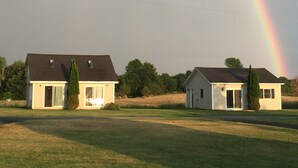 Deux maisons avec un arc-en-ciel en arrière-plan.