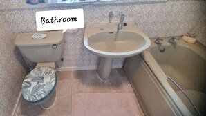Ein Badezimmer mit Toilette, Waschbecken und Badewanne.