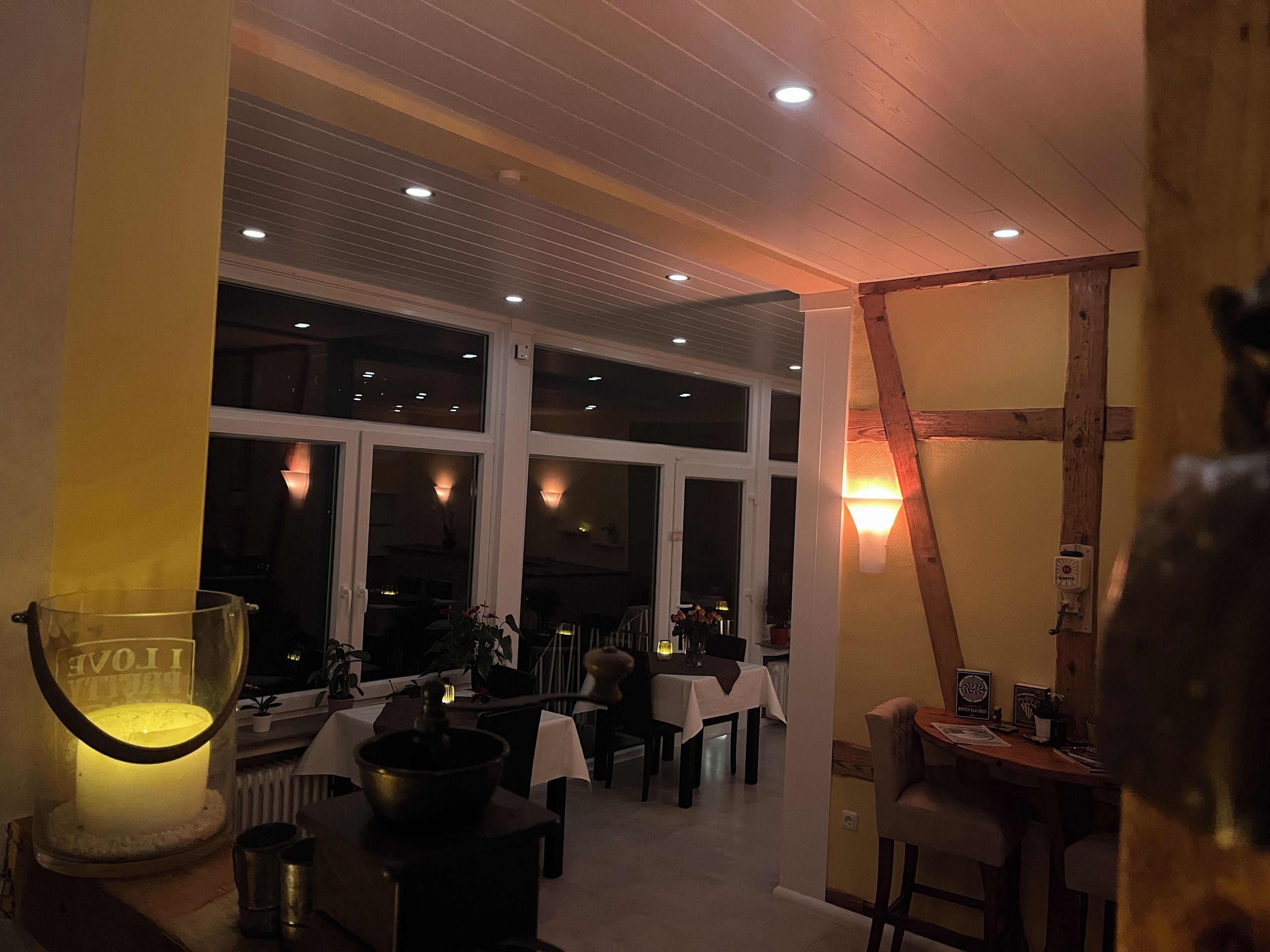 A dining area with tables, chairs, and a large window.