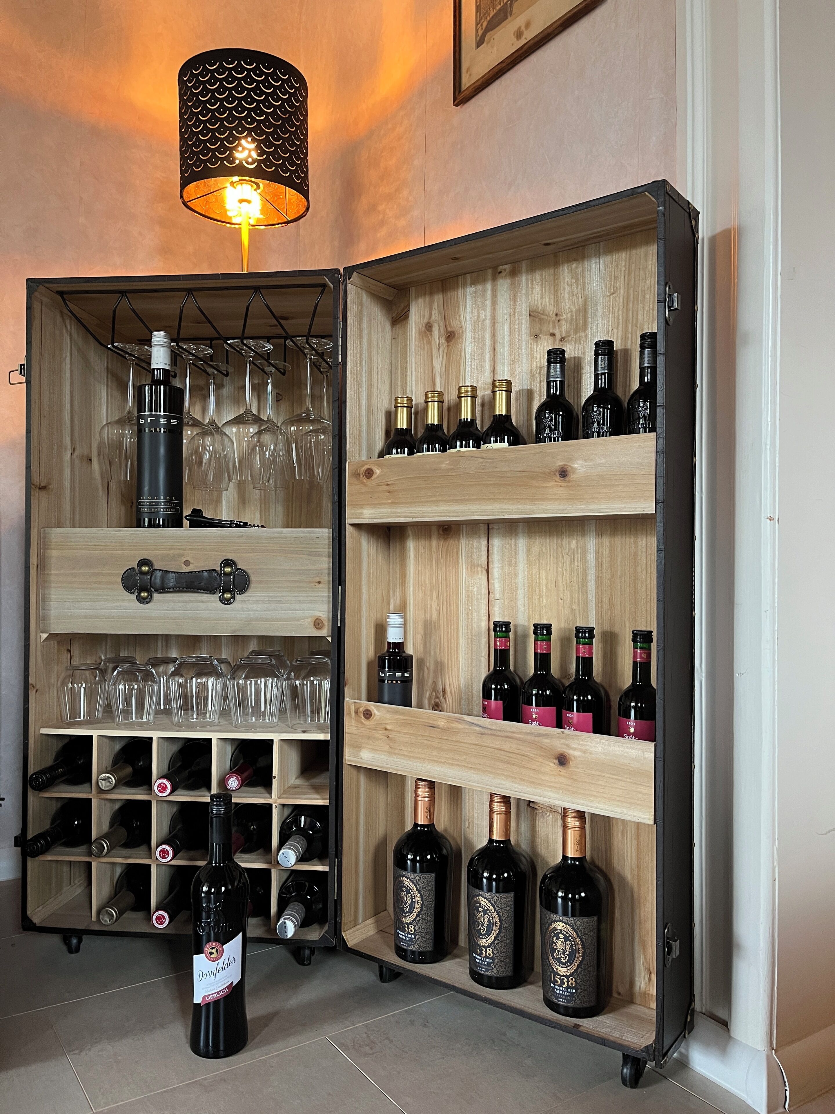Ein Weinschränkchen mit Regalen für Flaschen und Gläser, einem Flaschenöffner und einem hängenden Glasständer.