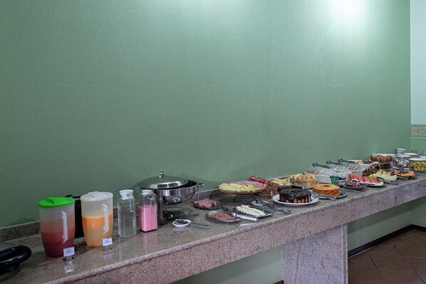 A buffet with various food items and drink dispensers.