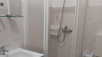 Un baño con ducha, inodoro y lavabo.