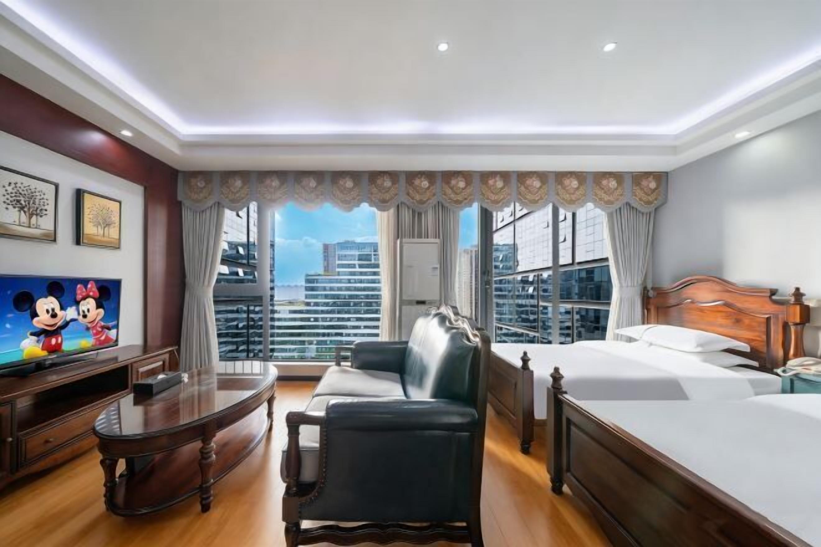 Une chambre d’hôtel avec un balcon, une télévision, un canapé et un lit.