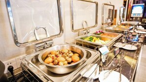 A buffet setup with various food stations, including a bowl of dumplings and a salad. - Westcare Hotel (Century City New Convention and Exhibition Center Tianfu 3rd Street Store) (Chengdu)