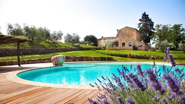 A swimming pool with a wooden deck, surrounded by lavender plants. - Villa Meraviglia With Pool And Ac (Poggibonsi)