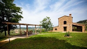 A stone building with a wooden pergola and a grassy lawn. - Villa Meraviglia With Pool And Ac (Poggibonsi)