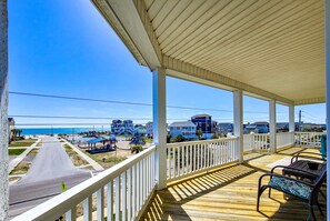 A covered outdoor area with a view of the beach and buildings in the background. - Dive into "Summer Days & Cooler Nights"! w/ pool! (Surf City)